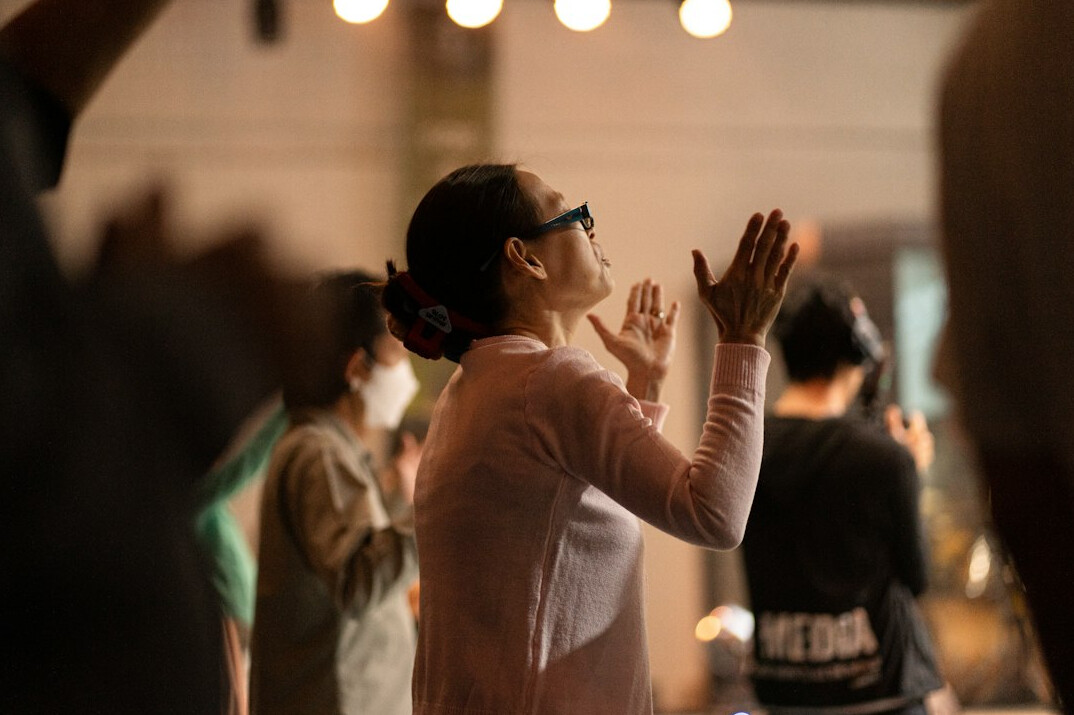 Brazilian woman speaking confidently and gesturing while presenting to a small group indoors