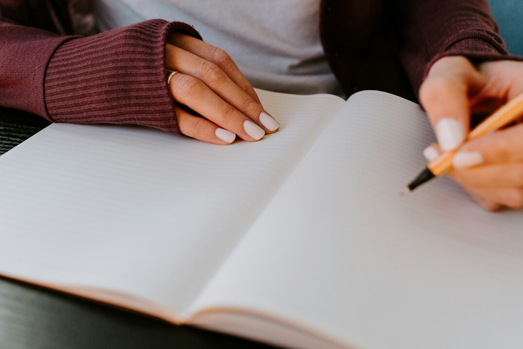 woman writing goals in journal